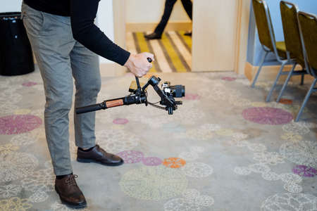 Steadicam in the hands of the cameraman, a stabilizer for video shooting from the hands, the guy...