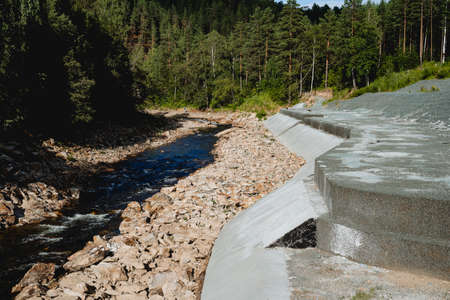 The dam is protective on a mountain river, a fortified structure made of concrete, protection of the...