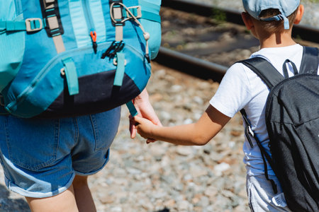 mom holds her hand on a hike, family travels with backpacks, walk together holding hands, follow me,...
