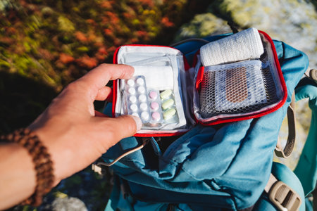 An open first-aid kit with medicines for a hike, a set of pills for vomiting, camping equipment, a tactical set of medicines.の写真素材