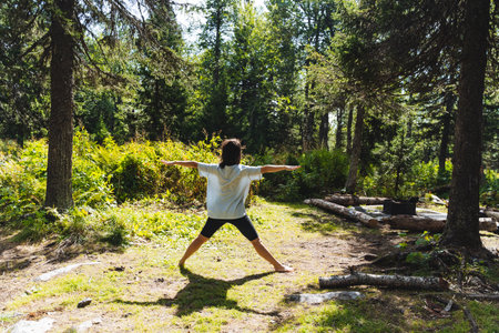 Yaga in the forest, girl doing practices in nature, balance asana, triangle pose, fitness in the fresh air. High quality photoの写真素材
