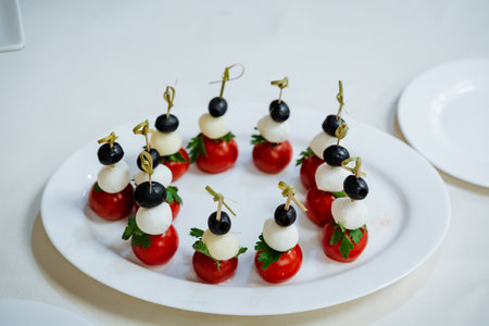 Cherry tomato and cheese canapes, beer appetizer, serving a plate with delicacies, bamboo skewer, takeaway. High quality photoの写真素材