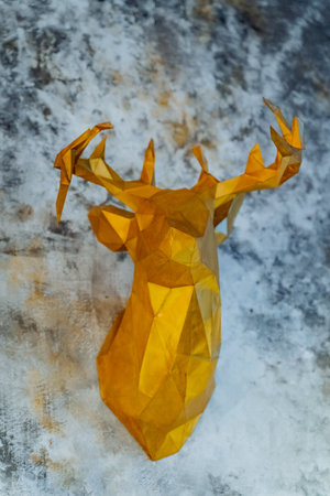 Paper reindeer golden color hanging on the wall in the house, reindeer head, symbol of new year and christmas. High quality photoの写真素材
