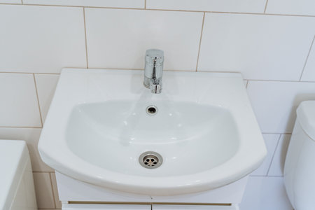 White sink wash basin, ceramic washbasin in the bathroom shot close-up. High quality photoの写真素材