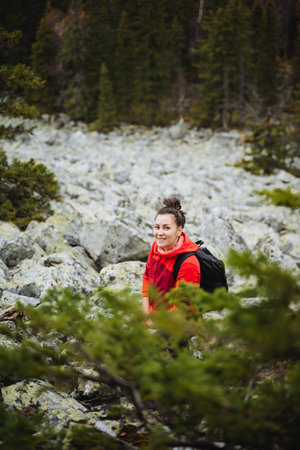 girl smiling standing in the mountains on the background of rocks, mountain tourist route, hiking in the forest. High quality photoの写真素材