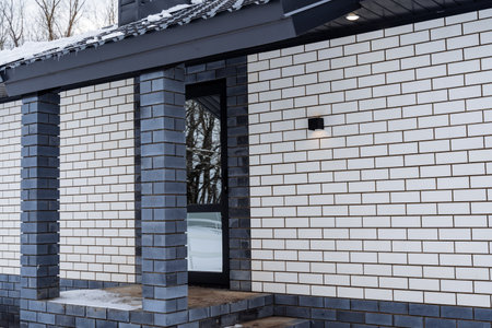 The porch of a country house, the entrance group with a glass door, a spot street lamp hangs on the wall of the house. High quality photoの写真素材