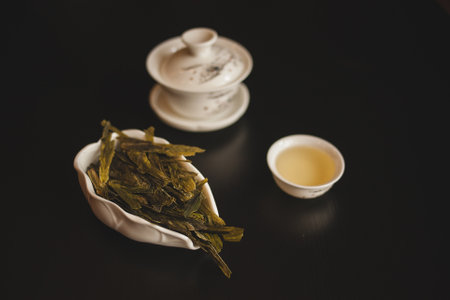 a bowl of green tea next to a cup of tea High qualityの写真素材