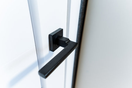 A closeup shot of an electric blue rectangular automotive door handle, made of metal and aluminum, mounted on a white vehicle doorの写真素材