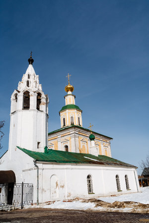 A historic site in the city, a white church with a green roof and bell tower stands tall against the...