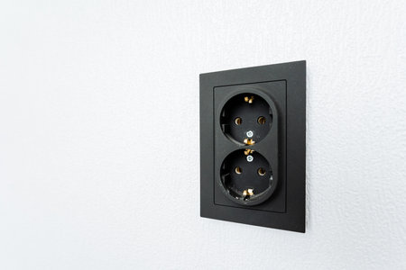 A rectangular black electrical outlet contrasts against the white wall, resembling a picture frame...