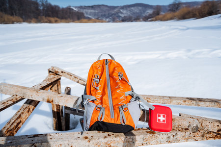Hiking equipment for trekking, an orange backpack and a red first aid kit. High quality photoの写真素材