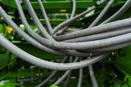 A network of cables connects the green machine to an electrical supply, resembling a plant with metal wires branching out like a terrestrial plantの写真素材