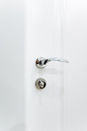 Shiny polished door handle on white background, home hardware, door lock with handle. High quality photoの写真素材