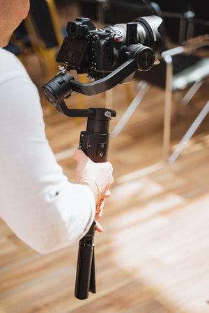 A person is setting up a camera on a wooden tripod at a photography event, the hardwood tripod...