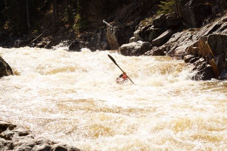 Person engaging in water recreation by kayaking down a river