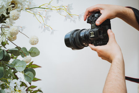 Photographer capturing flowers with digital camera and camera lens