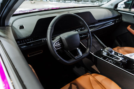 A steering classic car with brown seats and a wheel in the interior, along with a center console and vehicle door fixturesの写真素材