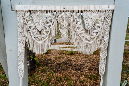 A wooden macrame table with a rectangular mirror on top, adding a touch of symmetry to the facade....