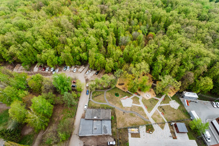 The aerial view showcases a park filled with trees and surrounded by buildings. The natural...