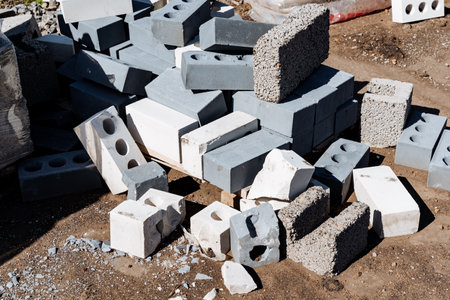 Heap of construction blocks and concrete bricks at building site in sunlight. Pile of durable...