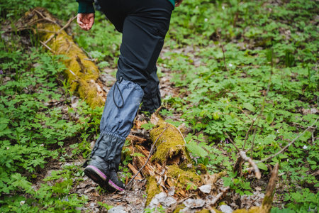 Capture the essence of outdoor adventure with this close-up of a hiker's legs navigating through...