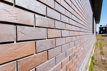 A detailed closeup of a red brick wall on a modern building in the countryside, highlighting its...