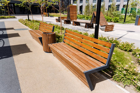 The park is equipped with wooden benches, a bin, and various natural elements like wood, grass, and...