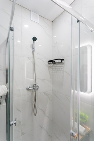 A bathroom that features a shower stall along with a conveniently placed mirror for daily grooming needs and personal care routinesの写真素材