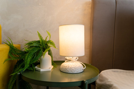 A beautiful lamp is elegantly placed on a vibrant green table that is situated right next to a...