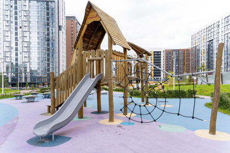 In a vibrant city park, there is an exciting playground featuring both a large slide and an engaging...