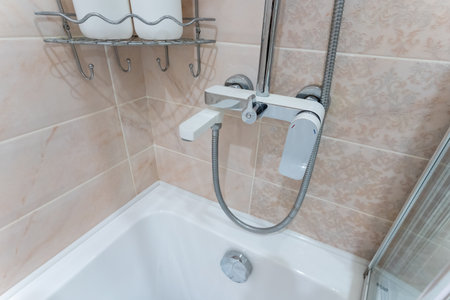 A bathtub that features a shower head attached to it, situated within a welldesigned bathroom
