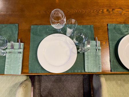 A beautifully arranged table featuring plates and glasses set up elegantly on its surface, ready for...