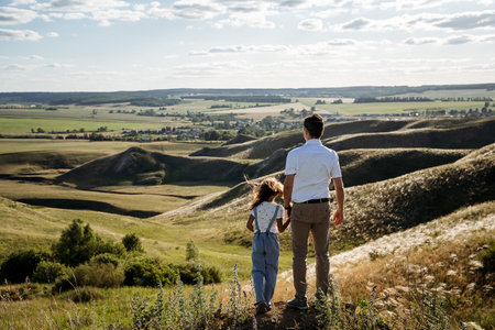In a beautiful landscape, a devoted father enjoys joyful moments with his daughter, highlighting natures beauty and their strong family bond during their adventuresの写真素材