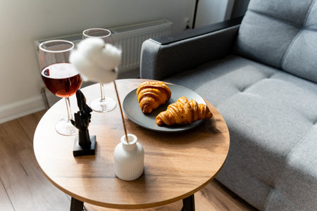 A beautifully arranged table with croissants and wine glassesの写真素材