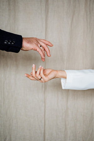 A beautifully detailed closeup of two hands gently reaching for one another, symbolizing deep intimacy, profound connection, and love in a captivating and serene settingの写真素材