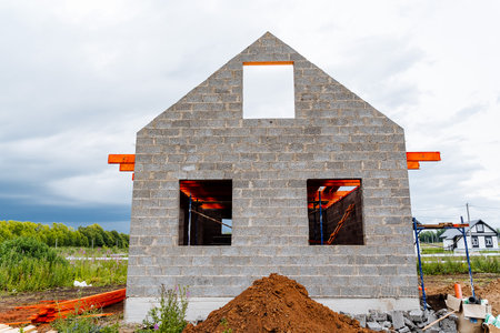 A contemporary house is currently under construction, showcasing a distinctive brick frame and large open windows.の写真素材