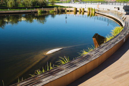 In the center of a beautifully maintained park, there is a large body of water that serves as a focal point for visitors and wildlife alike. It enriches the natural landscape surrounding itの写真素材