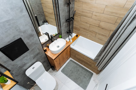 A welldesigned bathroom encompasses essential fixtures including a toilet, sink, and bathtub to cater to personal hygiene needs and enhance comfort, thereby fostering an inviting and cozy atmosphereの写真素材