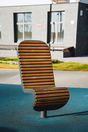 A wooden chair is sitting on a blue carpet in front of a buildingの写真素材