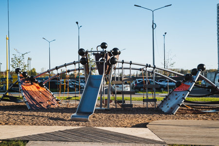 In a bustling urban area, there is a playground featuring an exciting slide and a challenging...