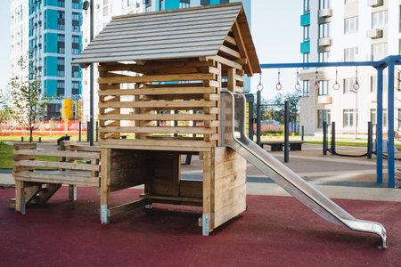 In a vibrant and lively playground, theres a charming wooden playhouse outfitted with a delightful slide, providing endless fun and entertainment for children to enjoy every day without failの写真素材