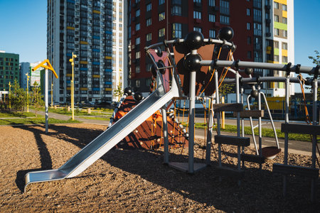 In a vibrant playground setting, there is a colorful slide designed for childrens play, with a tall,...