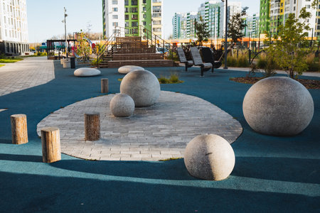 A colorful group of various balls is sitting on a vibrant blue surface in a public park, creating an inviting atmosphere for leisure activities and relaxation for the visitors of the areaの写真素材