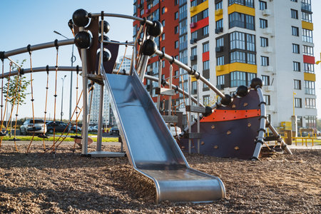 A colorful playground features a bright slide in front of a tall building, creating an exhilarating scene of urban life with leisure activities for everyone to enjoy and experience togetherの写真素材