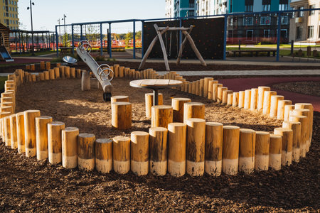 There is a charming playground enclosed by a sturdy fence constructed from logs, along with a sizable table for children to gather and play. This area encourages fun and engagement outdoorsの写真素材