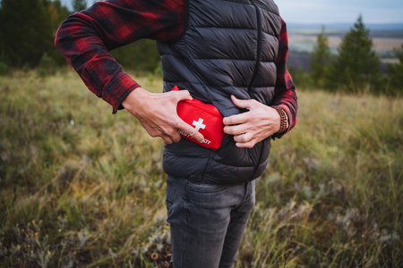 An individual is organizing their first aid kit in the beautiful outdoors, preparing for any adventure or unexpected emergency that may arise in the wildernessの写真素材