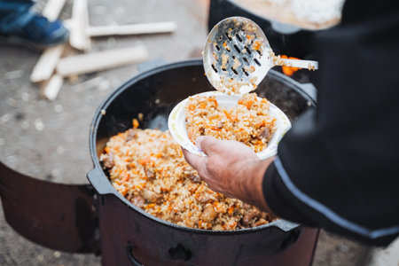 An individual pours a flavorful meal from a pot into a clean bowl, highlighting the artistry of cooking and the joy of sharing delicious food with loved ones and friends who appreciate itの写真素材