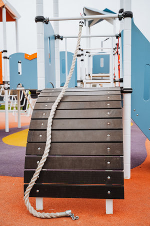 A strong rope is dangling down from a sturdy wooden structure that is part of a playground, creating an interesting element for children to play with and explore their surroundingsの写真素材