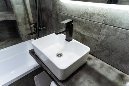 A wellequipped bathroom with essential features a practical sink, a relaxing bathtub for unwinding, and a conveniently positioned mirror for grooming, ensuring a pleasant experienceの写真素材