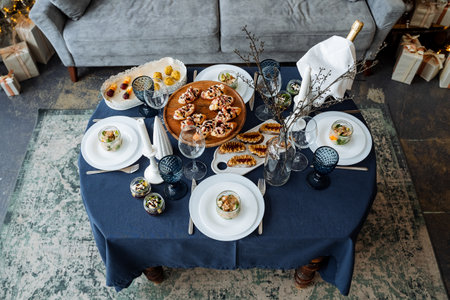 There is a beautifully arranged table that features plates, glasses, and a lovely bottle of wine on...